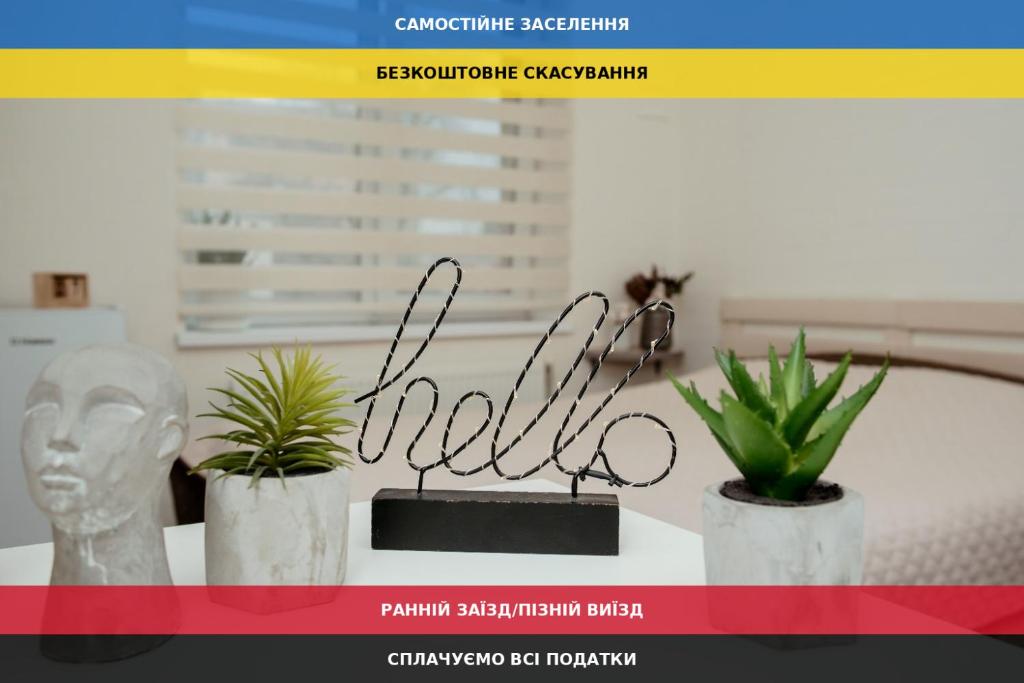 a table with two plants and a sign on it at Apartments at Kontorska 10 in Kharkiv