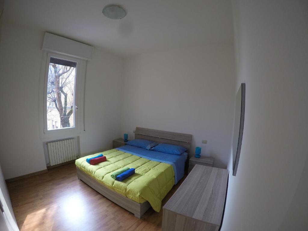 Schlafzimmer mit einem Bett und einem Fenster in der Unterkunft Corner Apartment in Bologna
