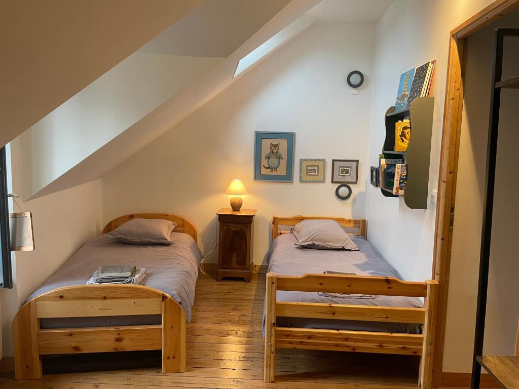 two twin beds in a room with a staircase at Maison de pêcheur proche du bourg in Ile aux Moines