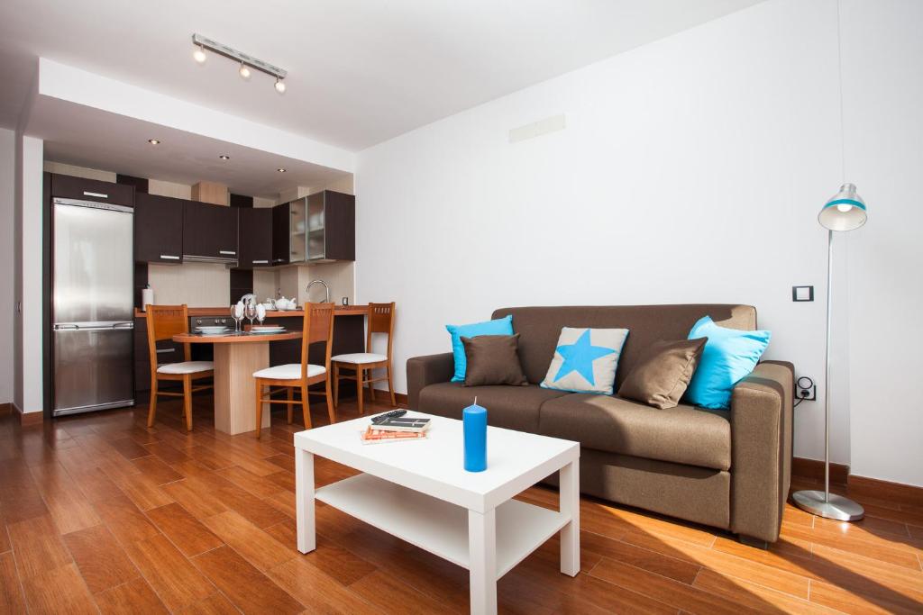a living room with a couch and a table at Corralejo Main Street Apartment in Corralejo