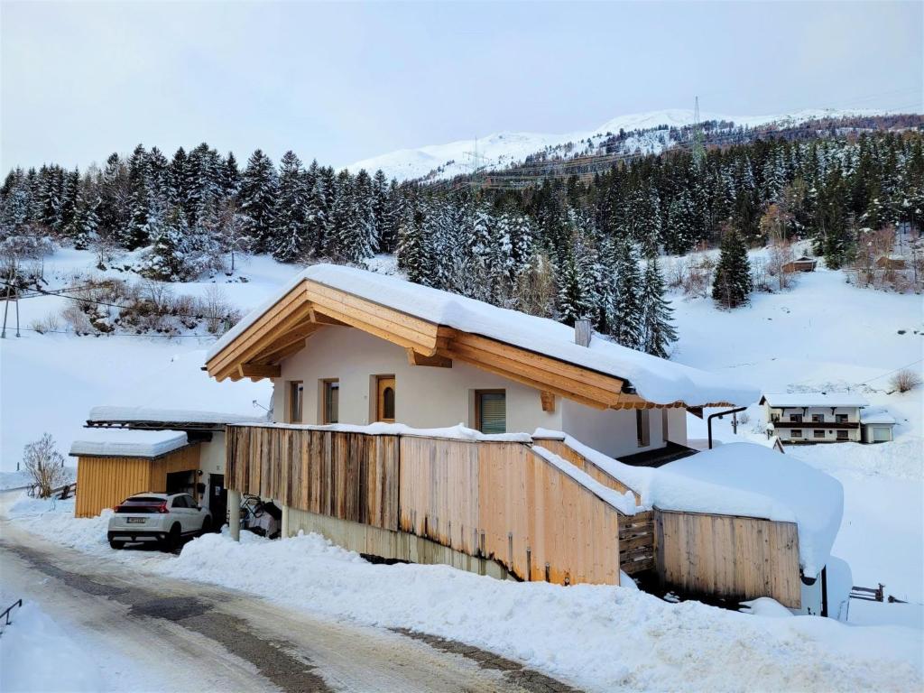 a house covered in snow with a car parked in front at Apartment Venet by Interhome in Wenns