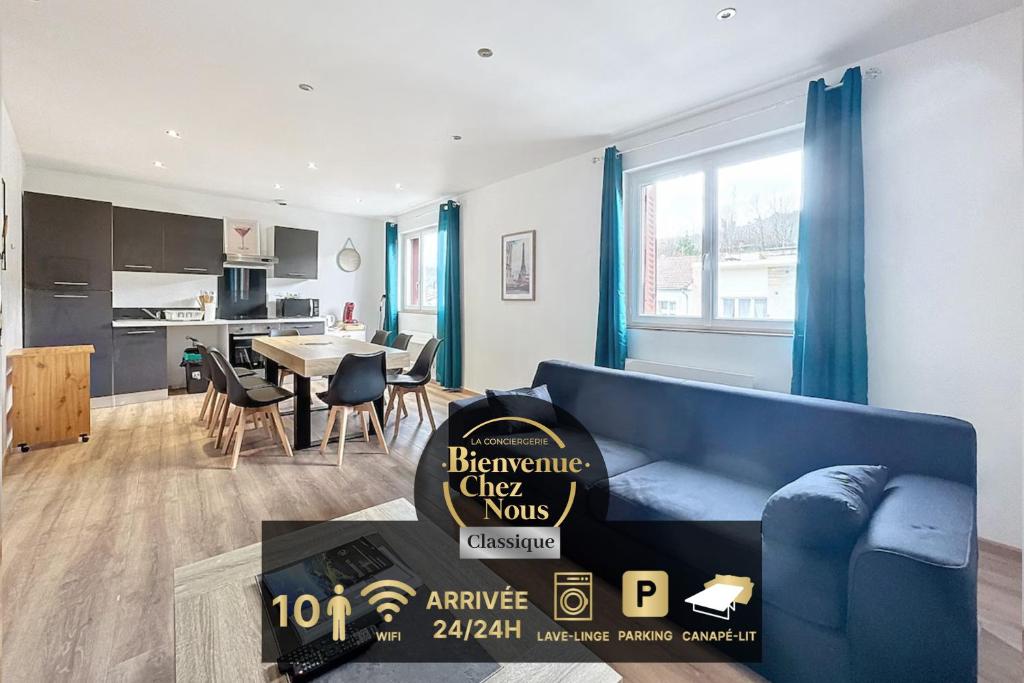 a living room with a blue couch and a kitchen at Apartment 10pers Aubière , Parking, WiFi - TV in Aubière