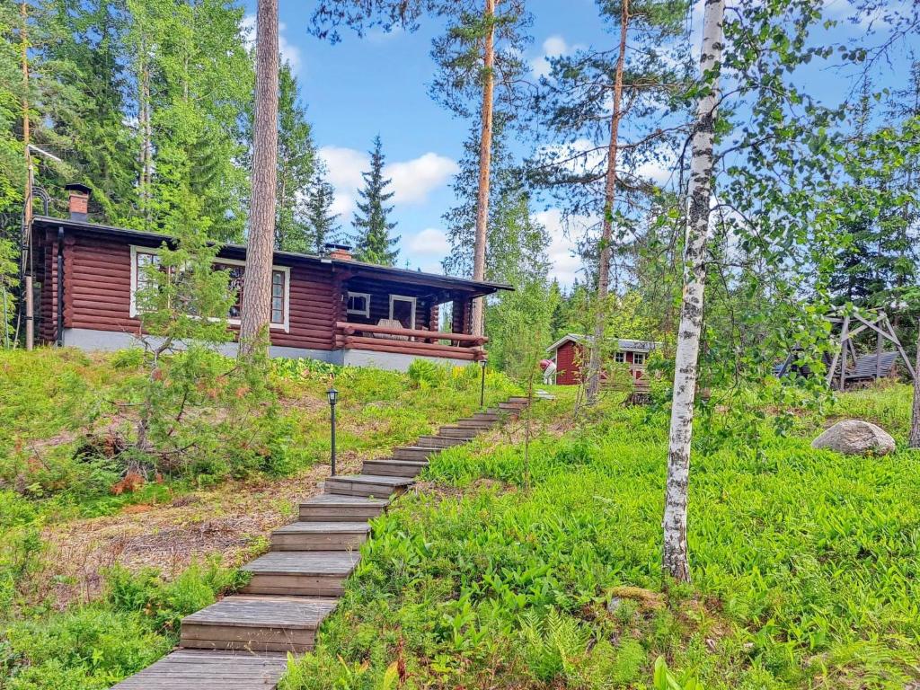 Una cabaña en el bosque con un camino de madera que conduce a ella. en Holiday Home Saaga by Interhome, en Ylöjärvi