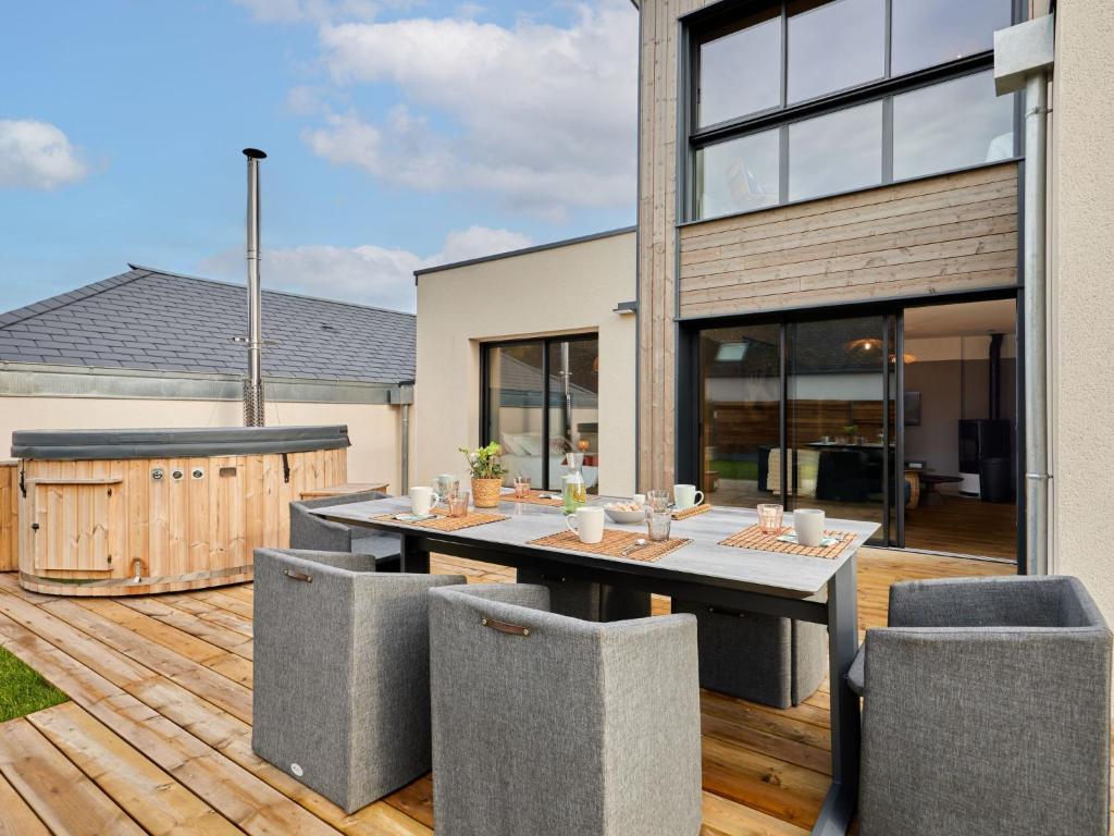 a patio with a table and chairs on a deck at Holiday Home L'Aventure Gouvillaise by Interhome in Gouville-sur-Mer