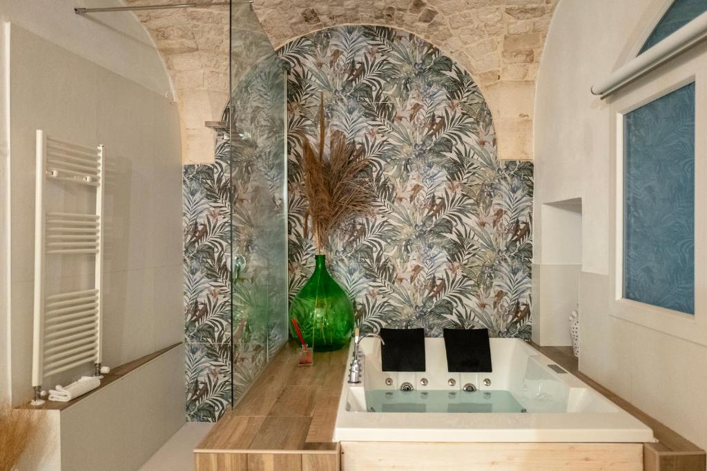 a bathroom with a green vase on a wall at Dimore Piazza Vecchia Wellness Suites in Castellana Grotte