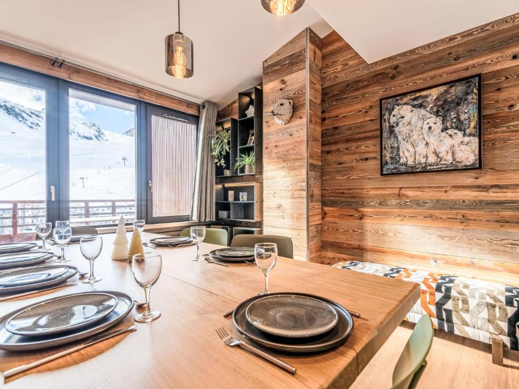 - une salle à manger avec une table en bois, des assiettes et des verres à vin dans l'établissement Apartment Le Curling B - Val Claret-43 by Interhome, à Tignes