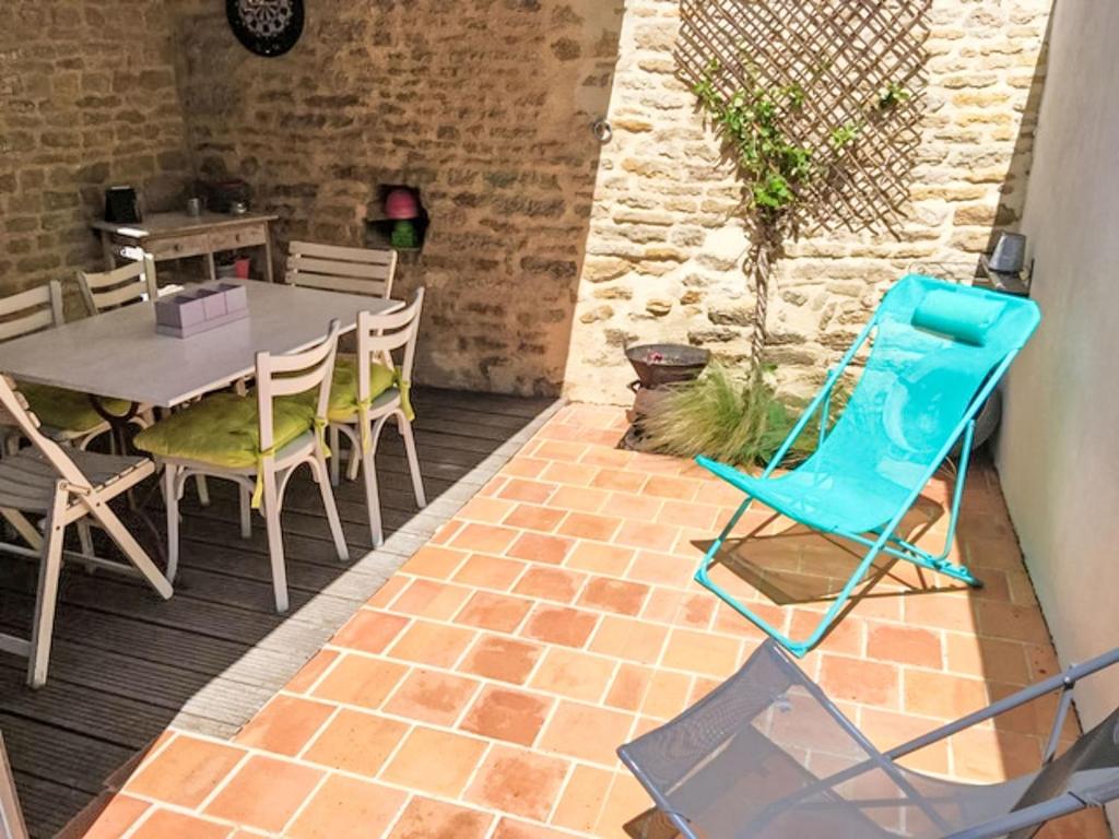 une terrasse avec une chaise bleue et une table dans l'établissement Holiday Home Ularius by Interhome, au Château-dʼOléron