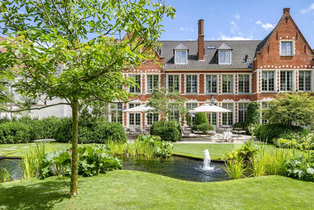 an exterior view of a large house with a fountain at The Notary in Bruges