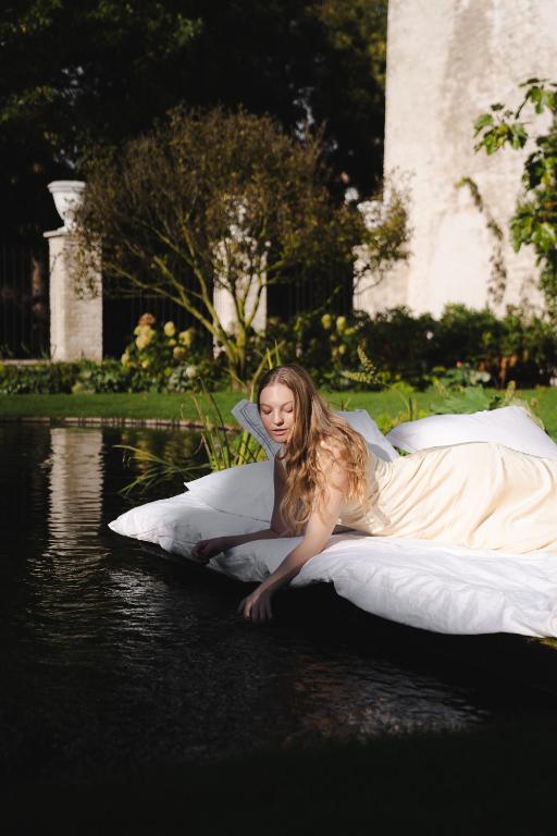 a young girl laying on a bed in the water at The Notary in Bruges