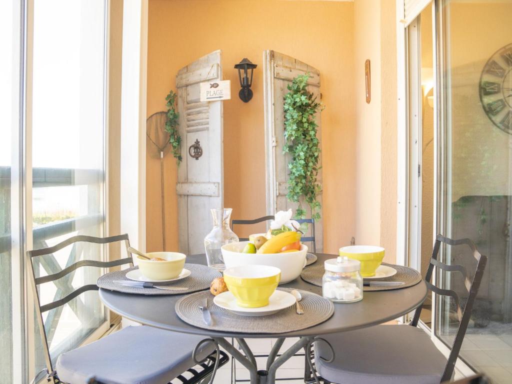une table avec un bol de fruits dessus dans l'établissement Apartment Les Terrasses du Lac-10 by Interhome, au Grau-du-Roi