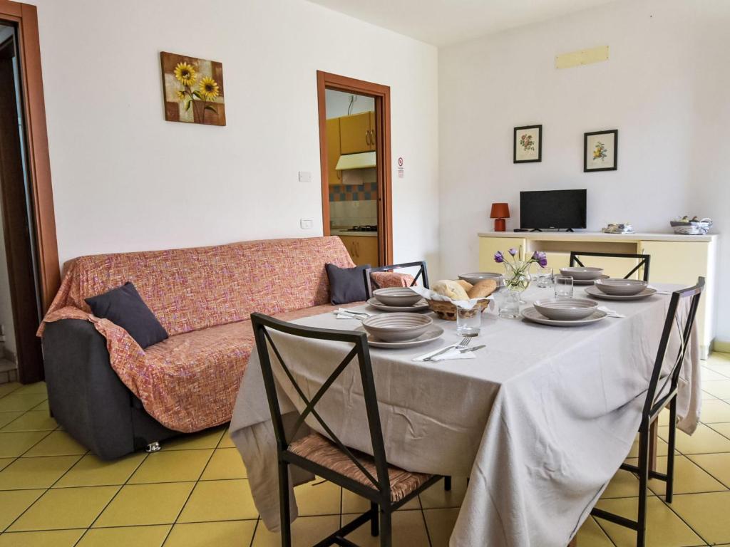 a dining room with a table and a couch at Apartment Solmare-52 by Interhome in Rosapineta