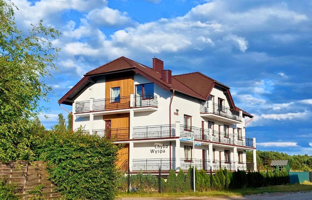 a large white building with a brown roof at Chyba Wyspa, Ostrowo in Ostrowo