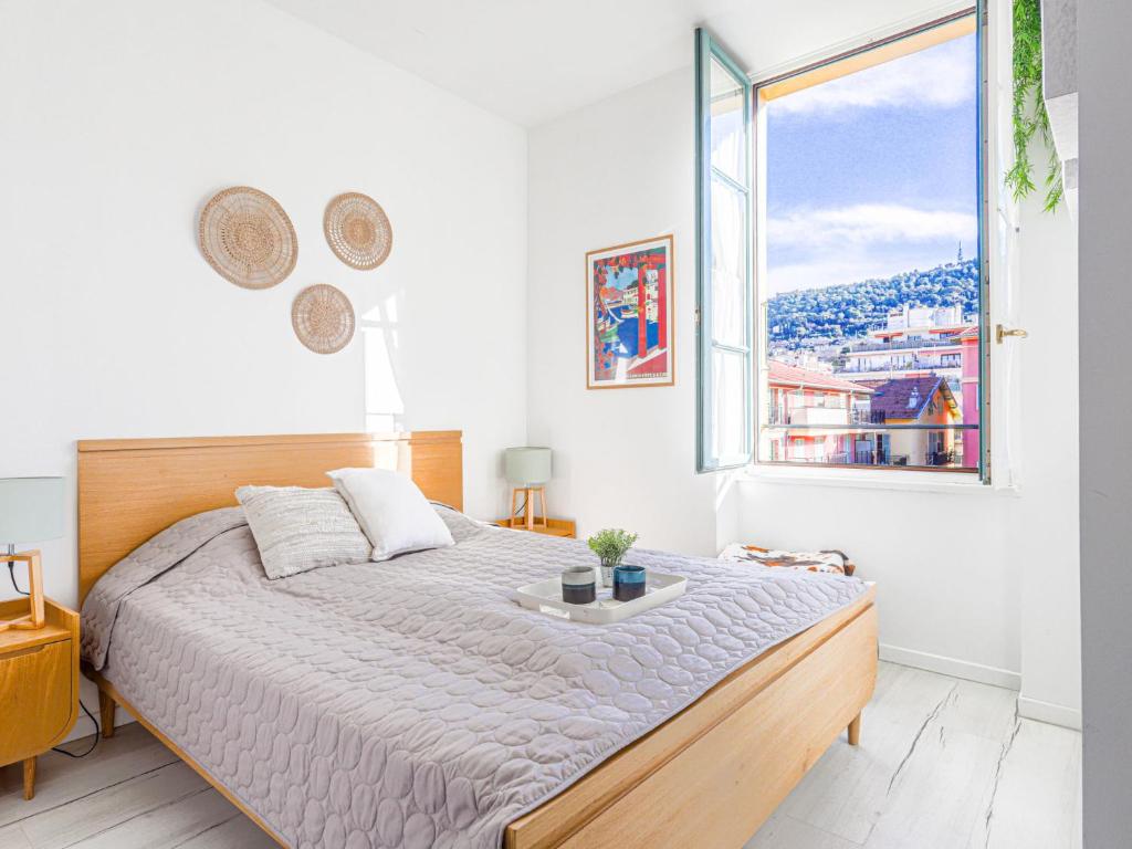 une chambre avec un grand lit et une grande fenêtre dans l'établissement Apartment Le Palais du Vieux Port by Interhome, à Nice