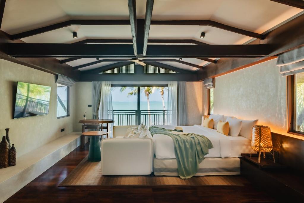 a bedroom with a white bed and a balcony at Barcelo Coconut Island, Phuket in Phuket Town