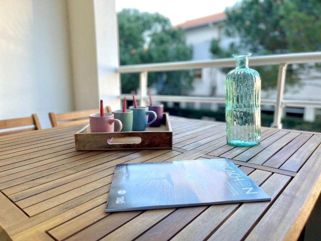 - une table avec un ordinateur portable et une bouteille de verre dans l'établissement Studio Le Trianon by Interhome, à Arcachon
