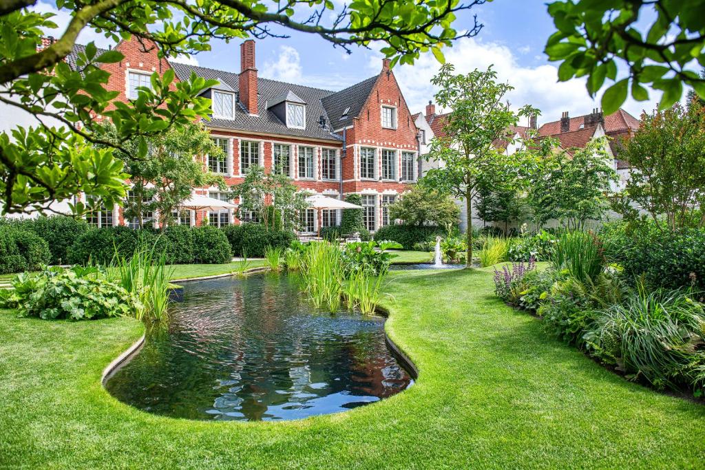 a large house with a pond in the yard at The Notary in Bruges