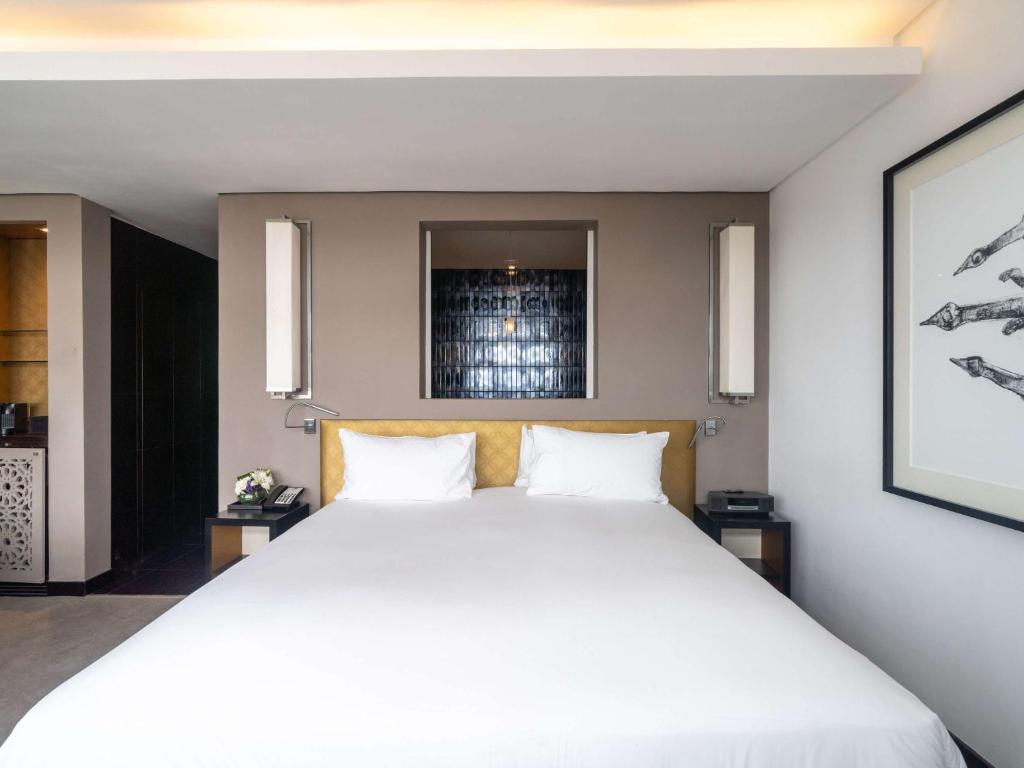 a bedroom with a large white bed with two pillows at Sofitel Casablanca Tour Blanche in Casablanca