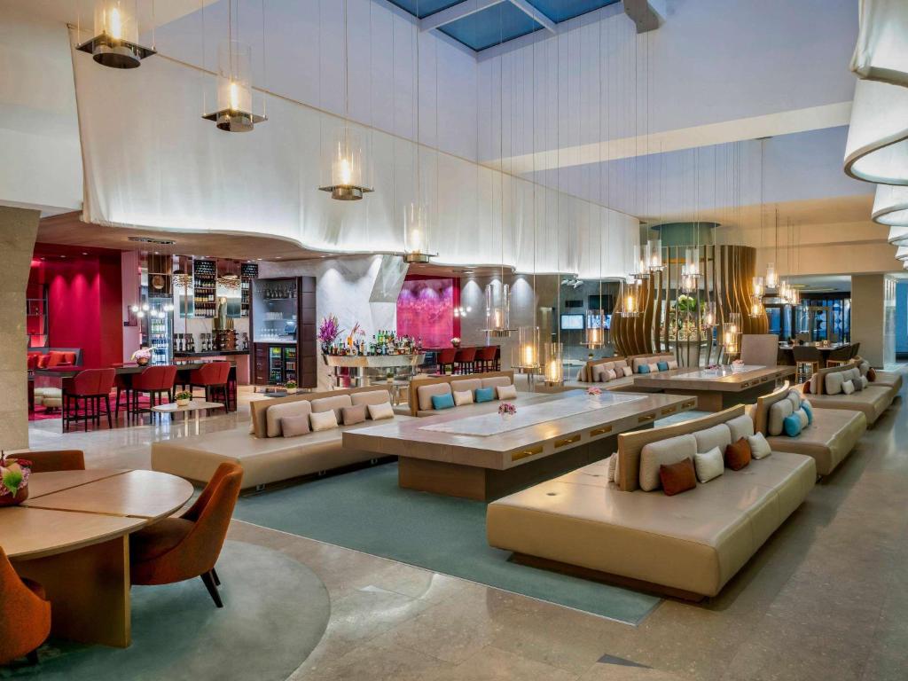 a lobby with couches and tables and a restaurant at Novotel Istanbul Bosphorus Hotel in Istanbul