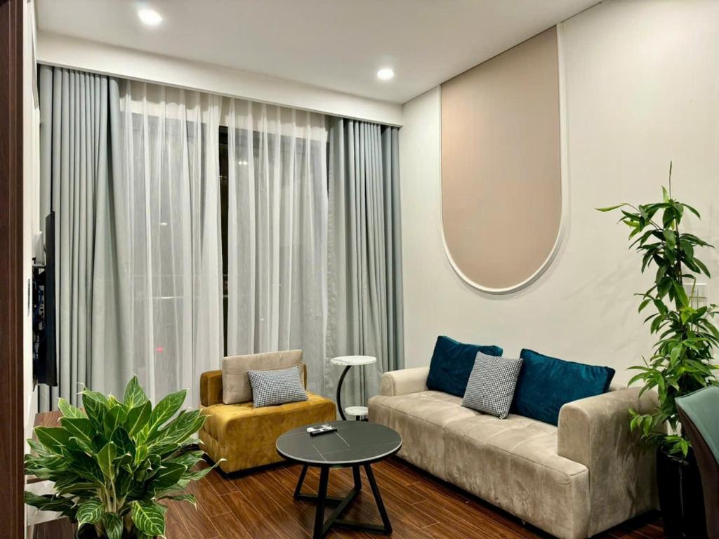 a living room with a couch and a round mirror at Căn Hộ 2 Phòng ngủ LUXURY-1516 in Gia Lâm Pho