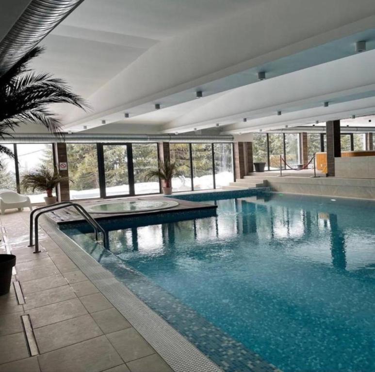 una grande piscina con acqua blu in un edificio di S&M Suncani Breg a Kopaonik