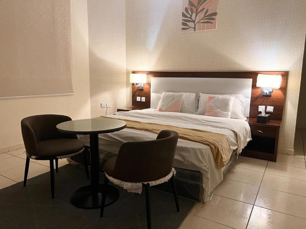 a hotel room with a bed and a table and chairs at قصر الريان in Buraymān