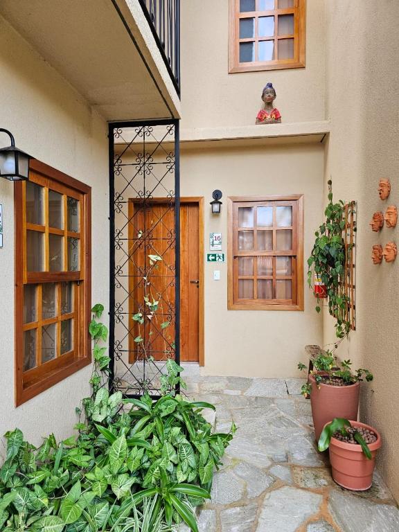 a front door of a house with potted plants at Pousada Mãe Natureza in Pirenópolis