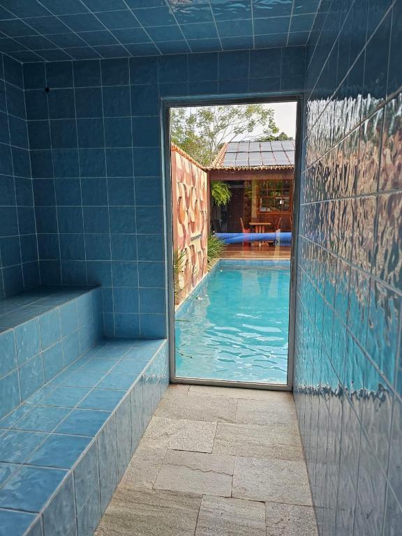 a blue tiled bathroom with a swimming pool at Pousada Mãe Natureza in Pirenópolis