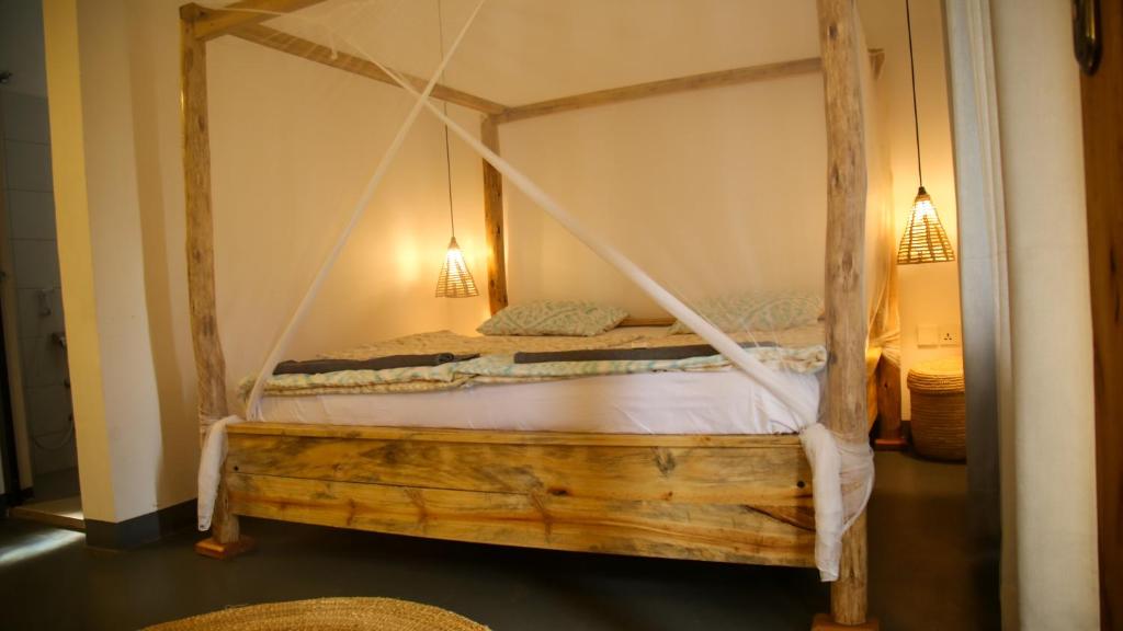 a bedroom with a wooden bed with a canopy at Hakuna in Arusha