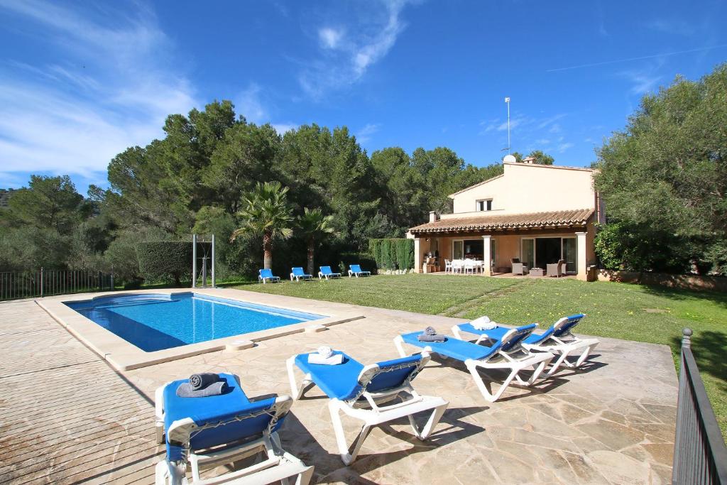 a group of chairs sitting next to a swimming pool at Son Cami in S'Horta