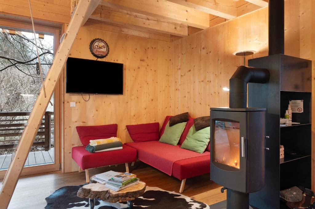 a living room with a red couch and a tv at Laugen Lodge in San Pancrazio dʼUltimo