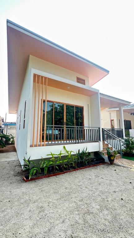 a house with a balcony with plants in front of it at Jenny Garden House in Ban Madua Wan