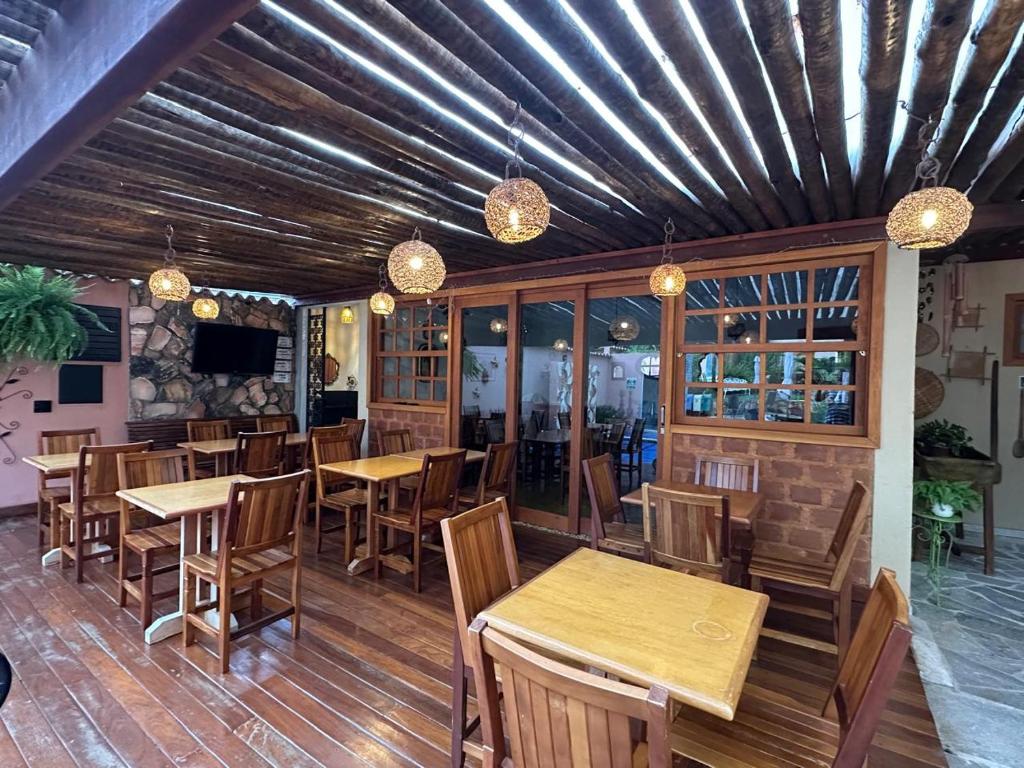 a restaurant with wooden tables and chairs and lights at Pousada Mãe Natureza in Pirenópolis