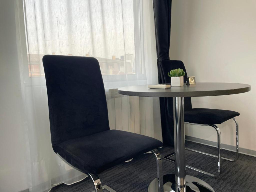 a table and two chairs next to a window at Sienna Apartments in Skopje
