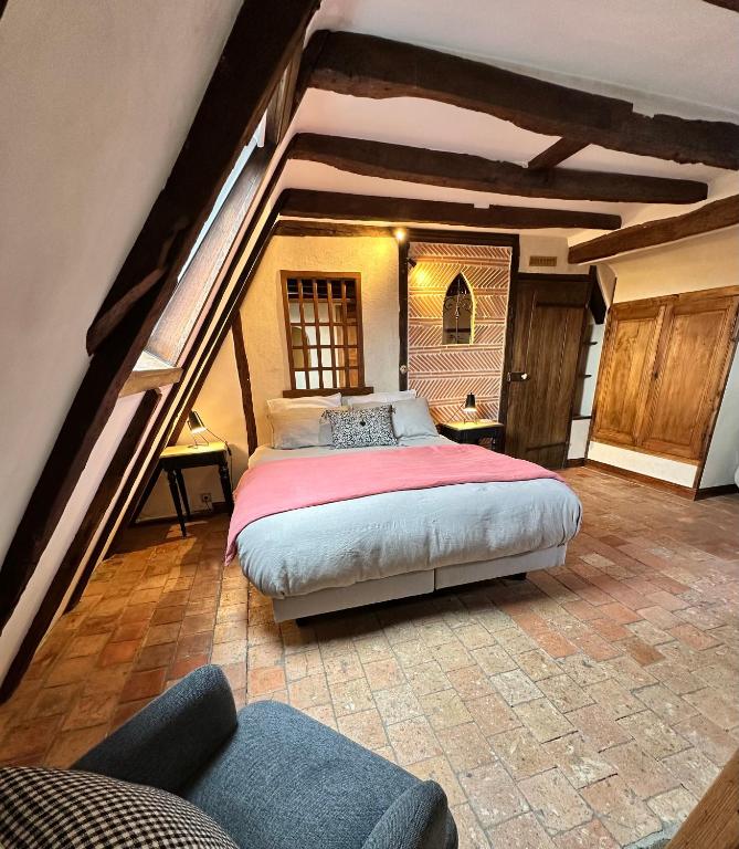 une chambre avec un grand lit dans un grenier dans l'établissement Le Petit Tinténiac - T2 cosy au cœur de la Doutre, à Angers