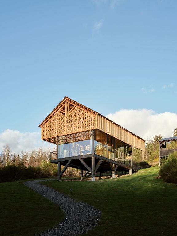 a building with a roof on top of a field at Hutstuf Bertogne in Bertogne
