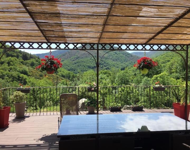 a patio with a table and a view of the mountains at Villa en pleine nature avec piscine in Sablières