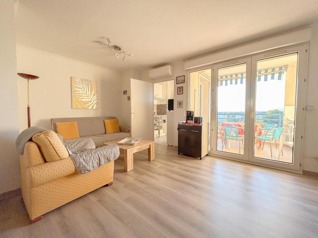 un salon avec un canapé et une table dans l'établissement Appartement F2 à Fréjus avec terrasse et parking, à Fréjus