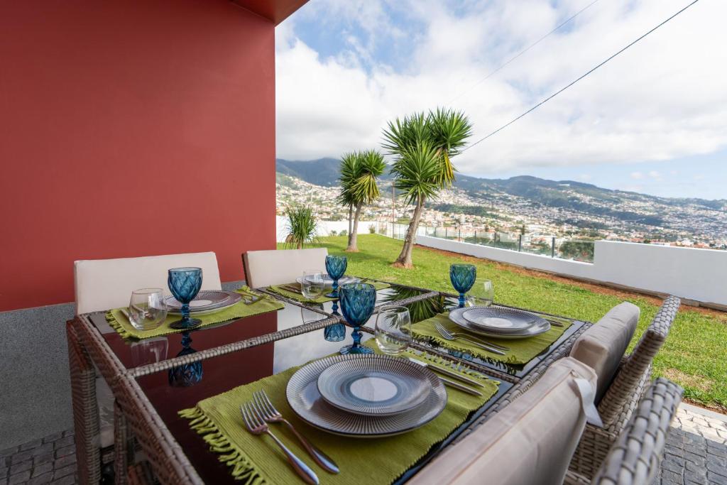 a dining table with a view of the city at Casa Terrea, vista Mar montanha ideal Familias ou Casais in Funchal