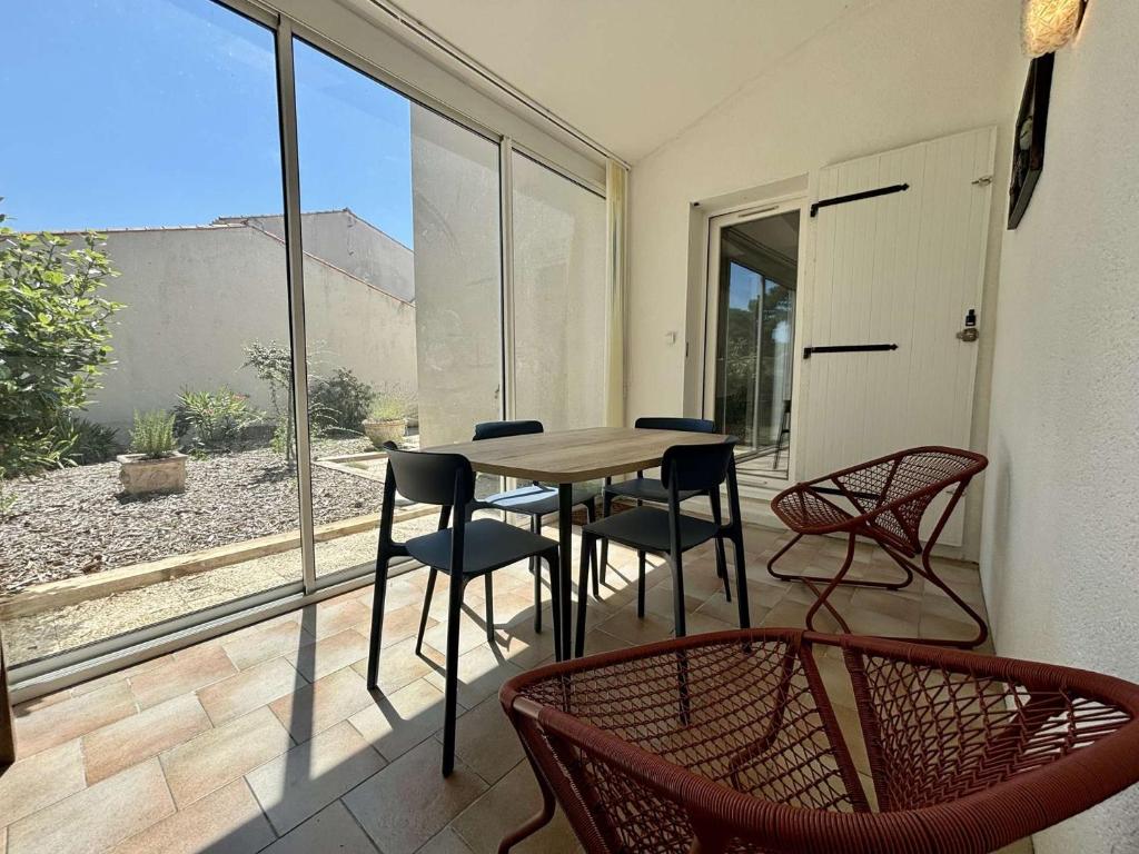 Cette chambre dispose d'une terrasse avec une table et des chaises. dans l'établissement Maison 3 pièces 4 couchages Saint Georges d'Oléron SGO000-098, à Les Sables Vignier