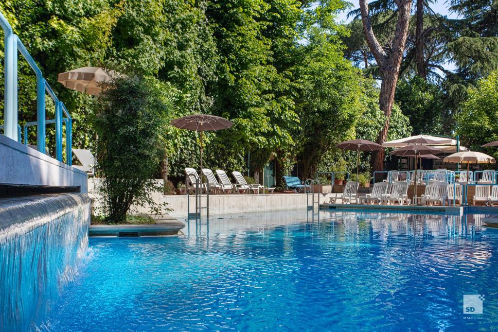 a swimming pool with chairs and umbrellas in a resort at Aldrovandi Residence City Suites in Rome