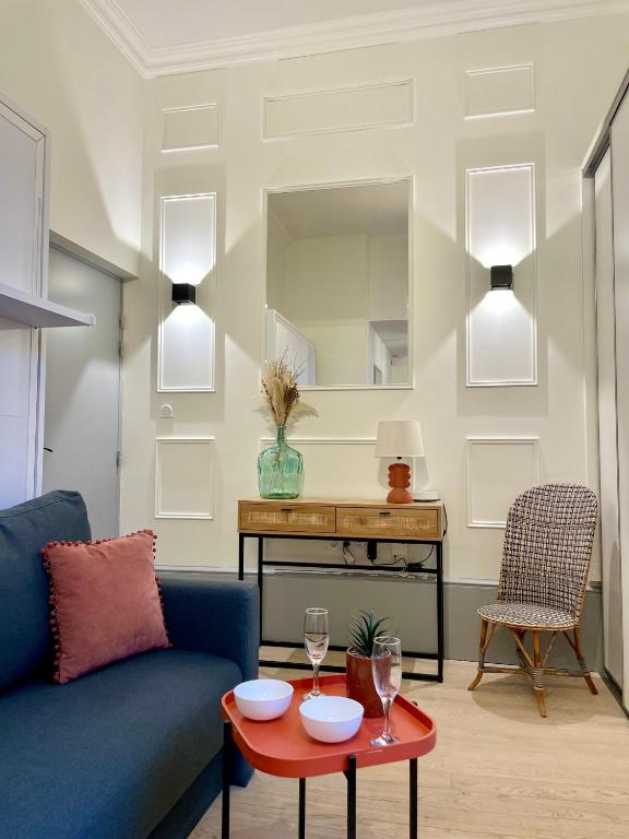 un salon avec un canapé bleu et une table dans l'établissement Studio Cosy Le Bareuzai, à Dijon