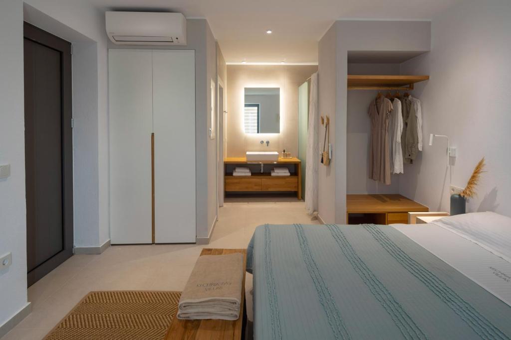 a bedroom with a bed and a bathroom with a sink at Kechria Bay Villas in Skiathos