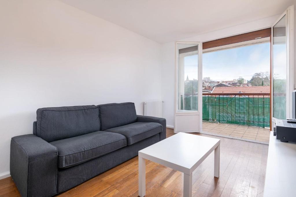 un salon avec un canapé et une table dans l'établissement Buissière Apartment - Cozy for 4 people in Oullins, à Oullins