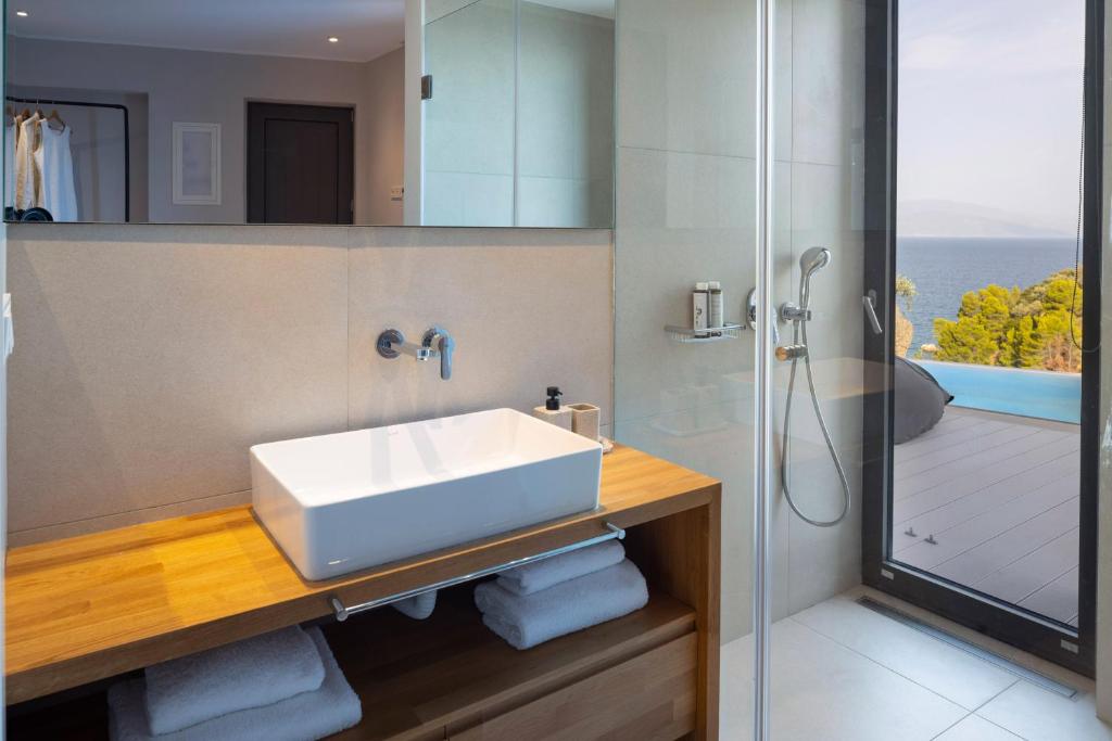 a bathroom with a white sink and a shower at Kechria Bay Villas in Skiathos