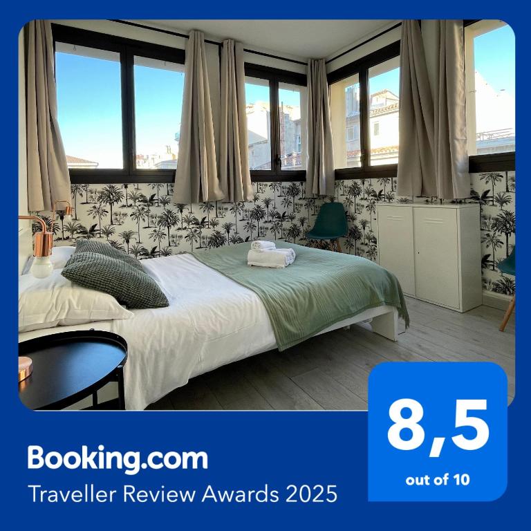 une chambre avec un lit dans une pièce avec des fenêtres dans l'établissement NOCNOC Le Capucin, à Marseille