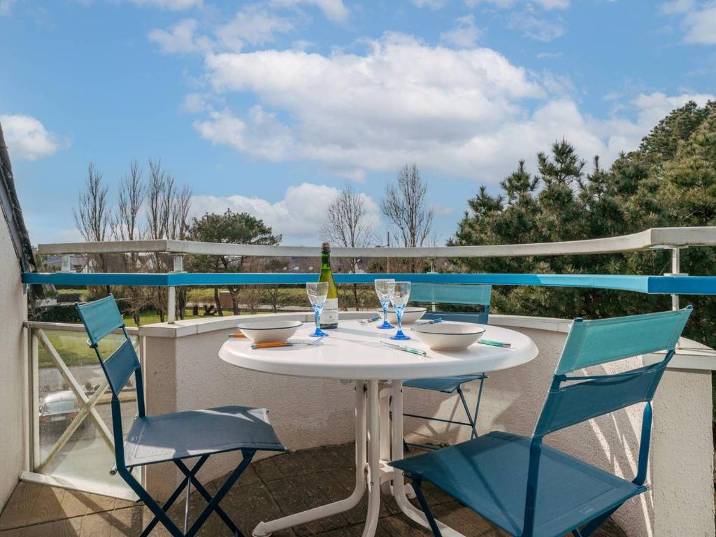 - une table et des chaises sur un balcon avec une bouteille de vin dans l'établissement Studio cosy à Carnac, proche plages, avec balcon, parking, et équipements modernes pour 3 personnes - FR-1-477-45, à Carnac