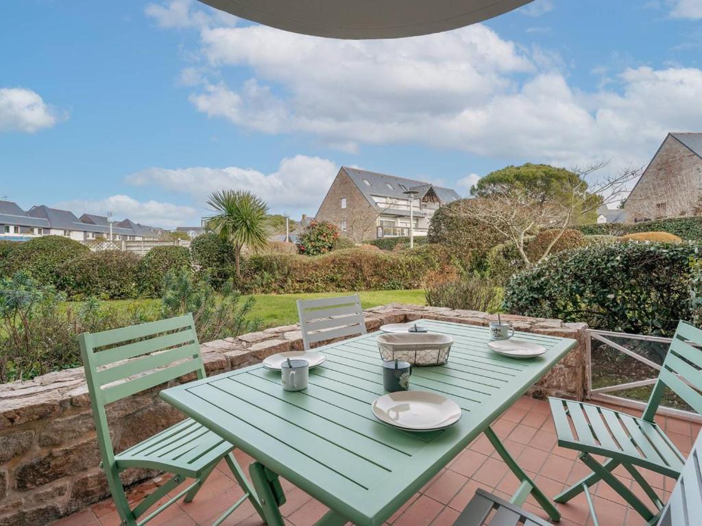 une table et des chaises vertes sur la terrasse dans l'établissement Carnac : Bel appartement 2 pièces avec terrasse exposée Sud-Est à 500m des plages, parking inclus - FR-1-477-214, à Carnac