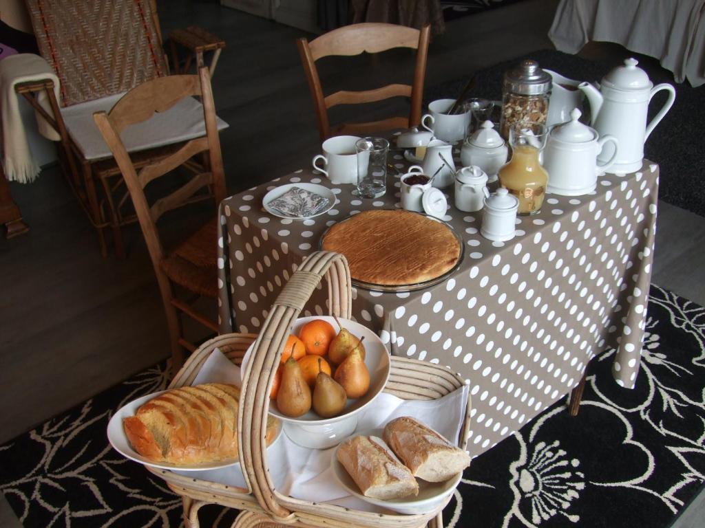 einen Tisch mit einem Teller Brot und einer Schale Obst in der Unterkunft La Maison Salée in LʼAiguillon-sur-Mer
