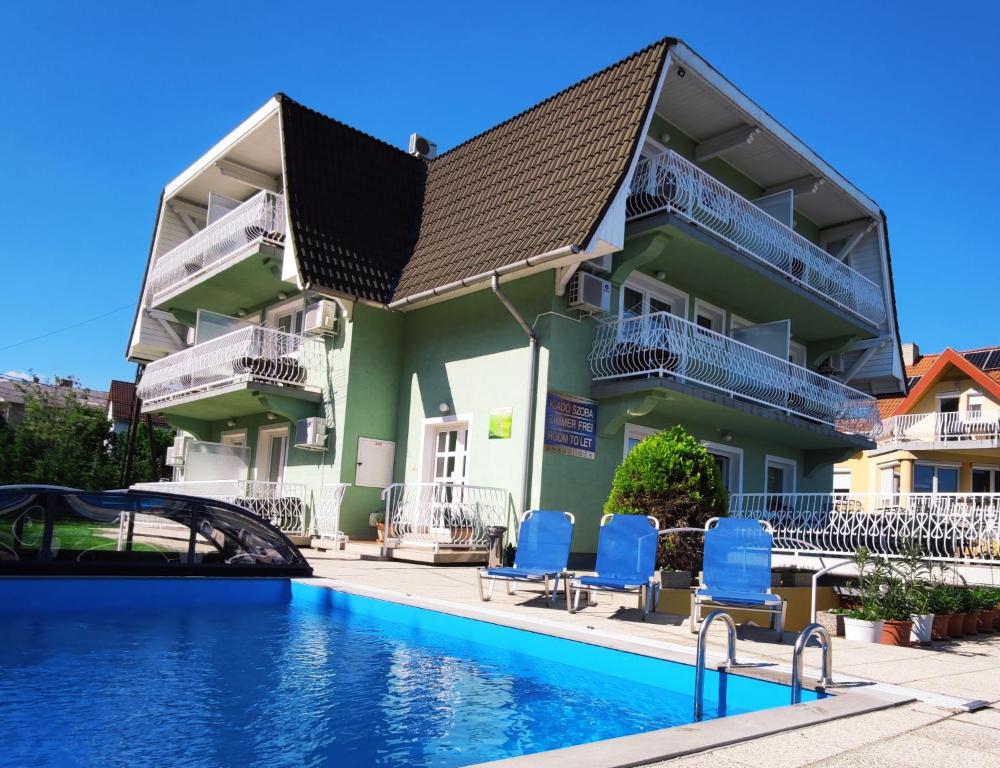 um prédio com piscina e cadeiras azuis em Zöld Vendégház em Balatonfüred