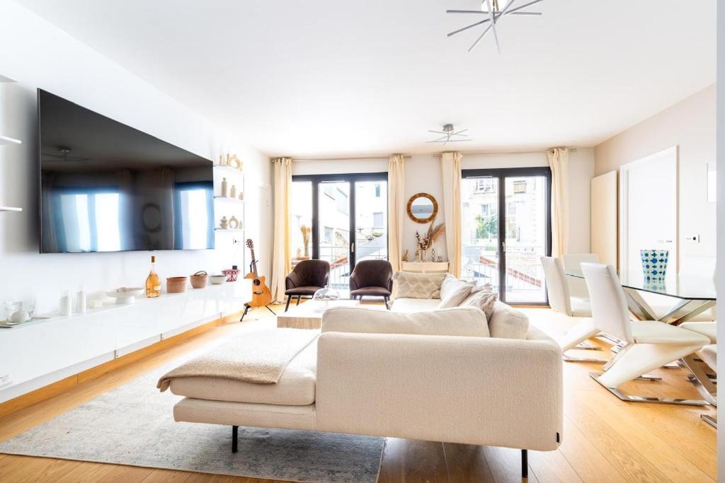 un salon avec un canapé blanc et des chaises dans l'établissement Appartement - Paris, France, à Paris